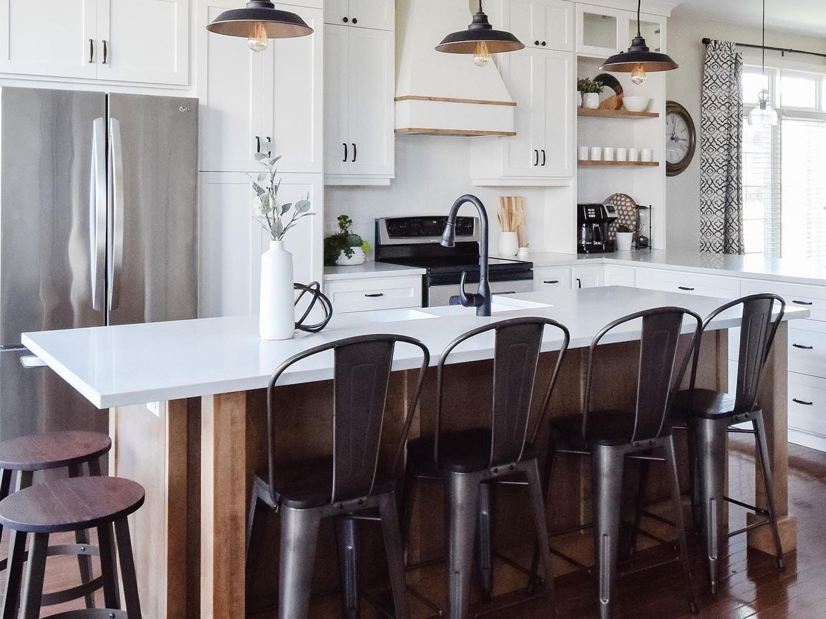 White shaker kitchen remodel with a quartz-topped wood island, metal counter stools and pulley pendant lights, San Antonio